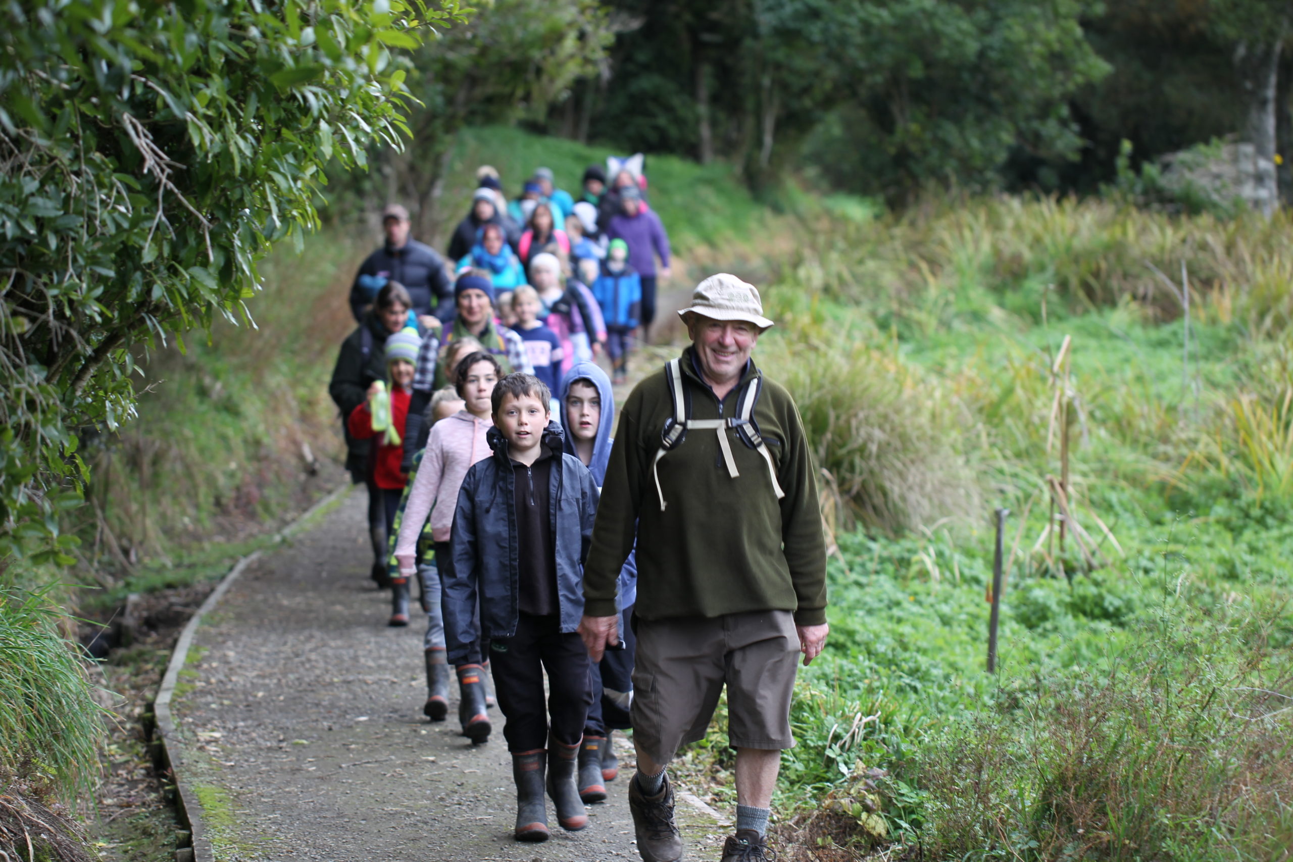 A man leads a group along walkway