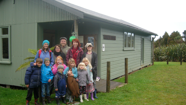 Group of adults and children in front of a building