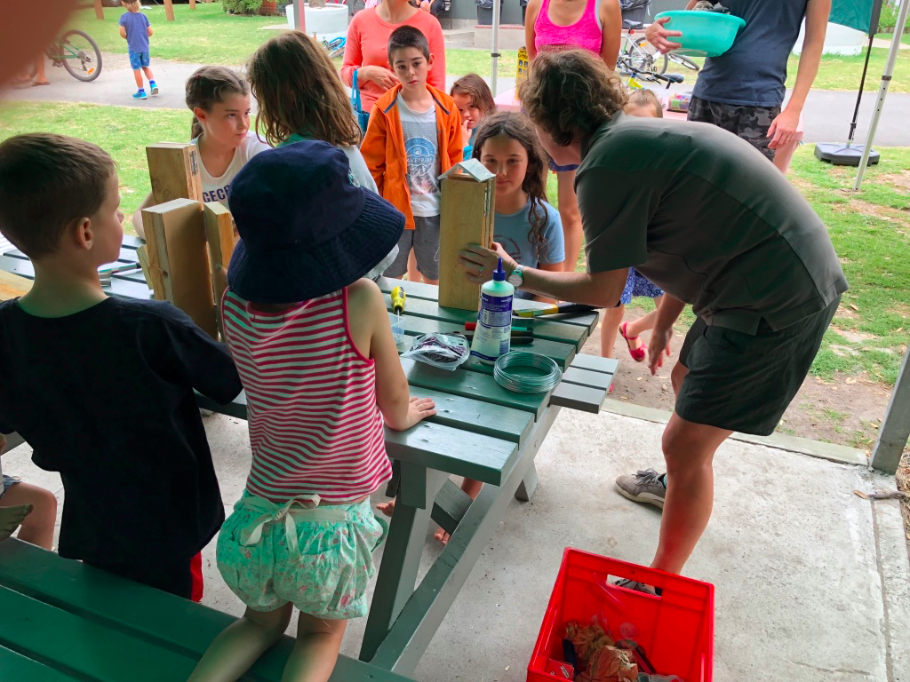 A local DOC ranger helps children make weta hotels at a holiday park.