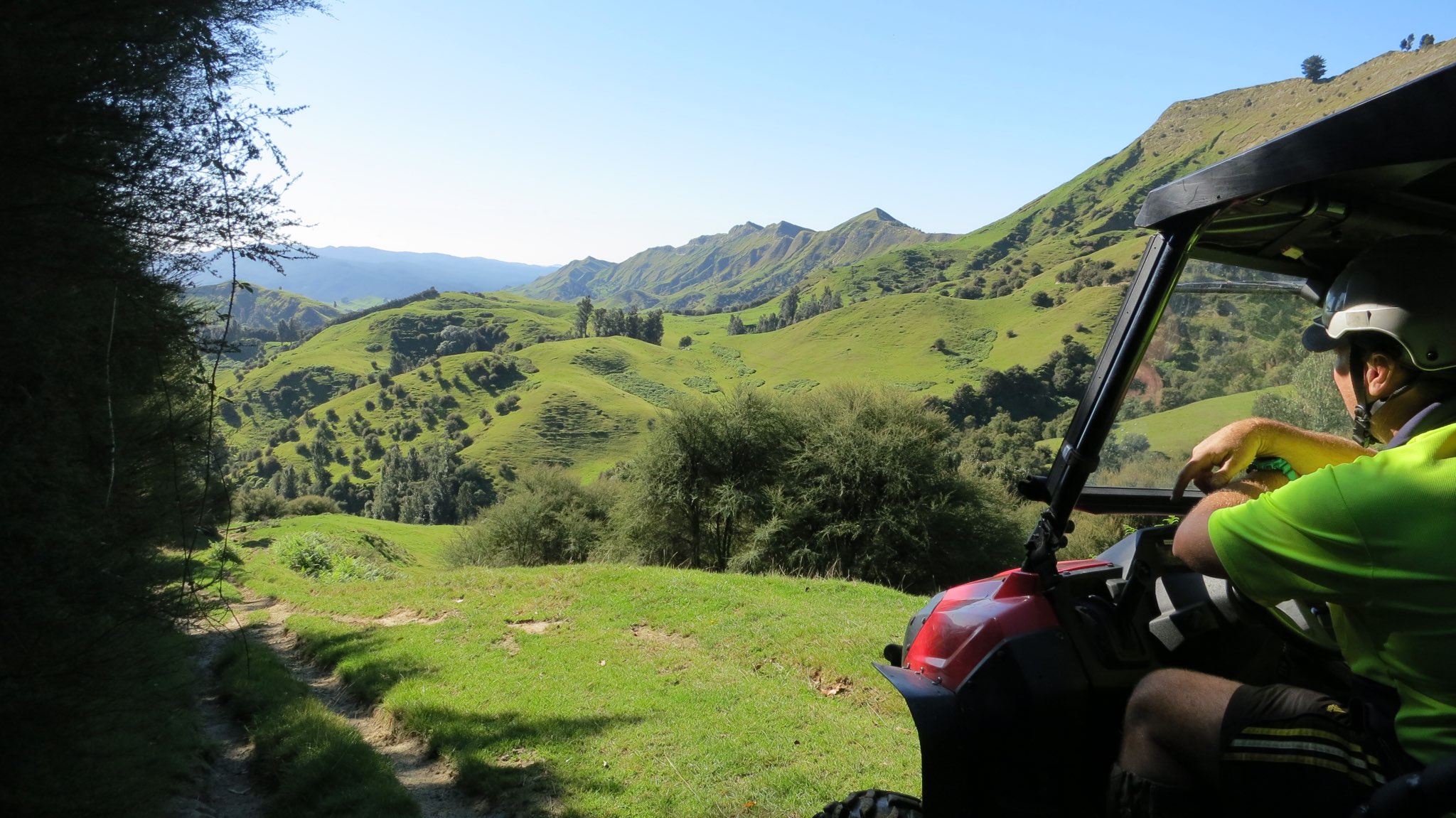 A view of farmland with a person sitting a vehicle