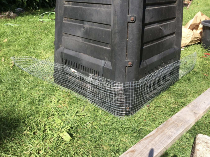 Photo showing netting around the base of a compost bin.