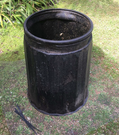Round bin with netting laid out on the ground.