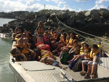 A group of children on a boat arriving on Limestone Island