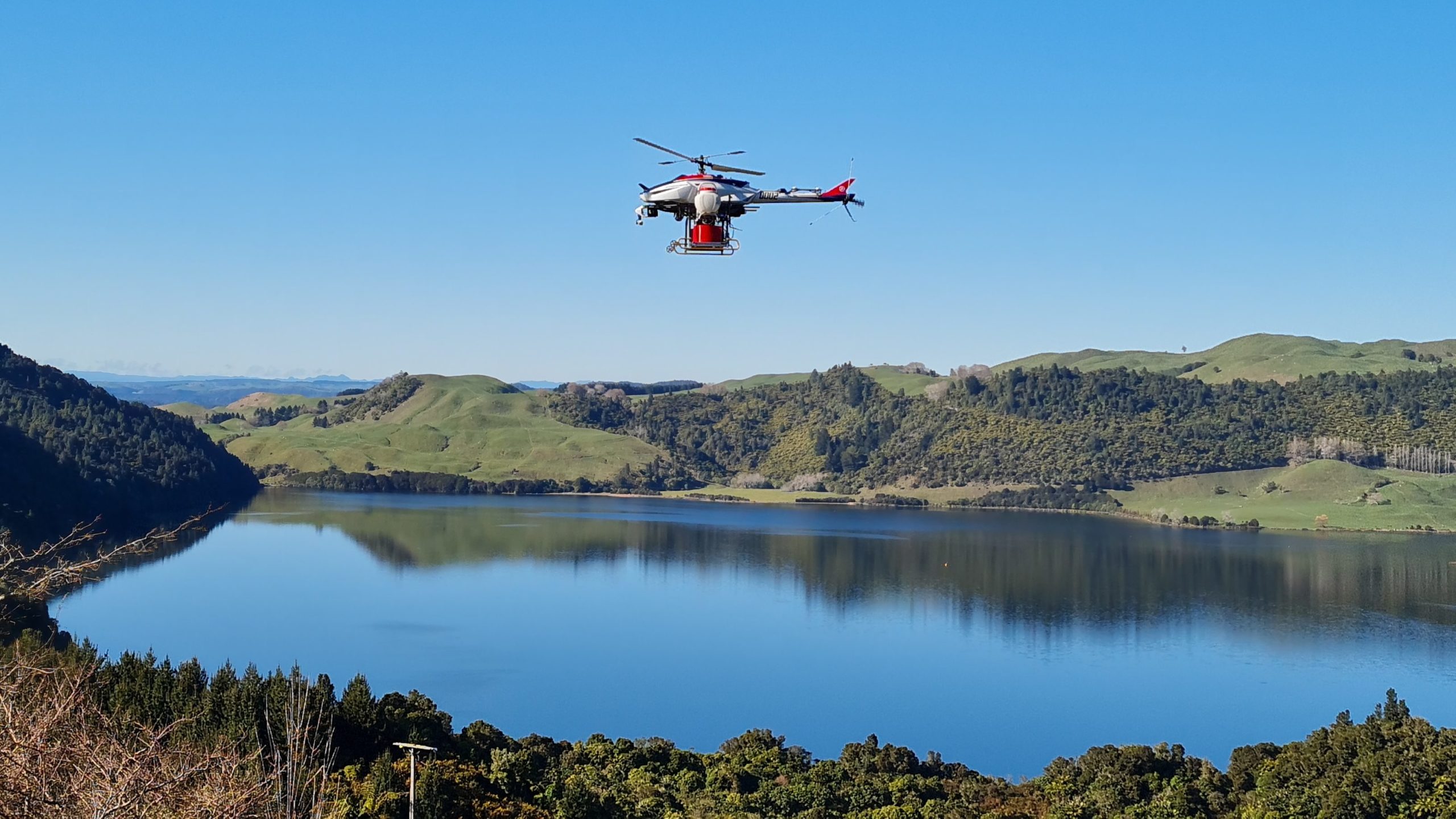 A drone in flight over a body of water.