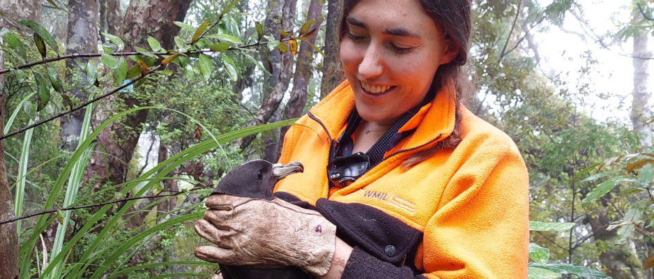Marcia holding a petrel in the bush.