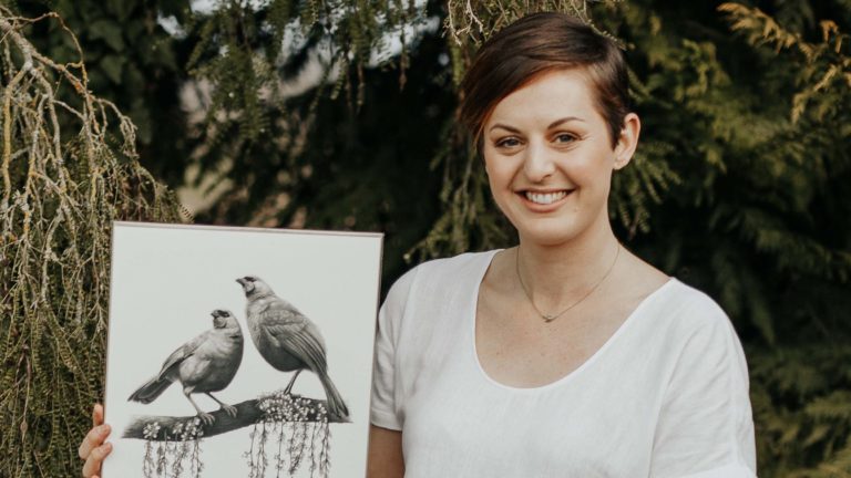 Hannah holding one of her art pieces.