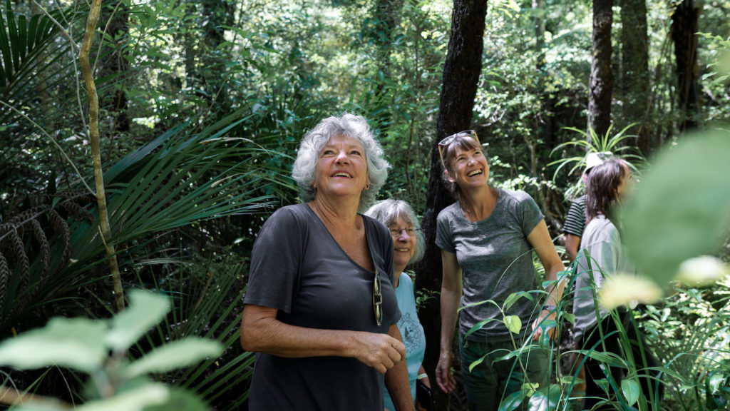 Three women standing in the bush.