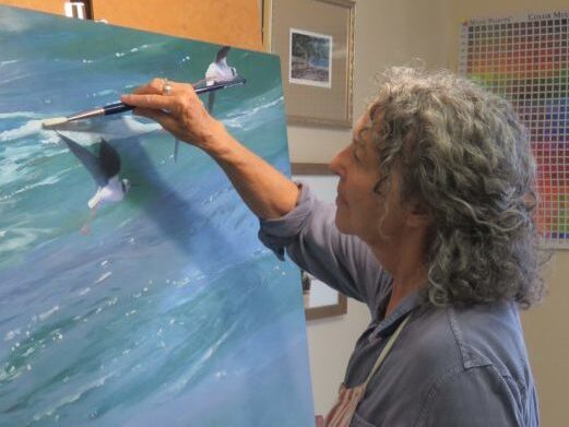 Lady painting an ocean scene