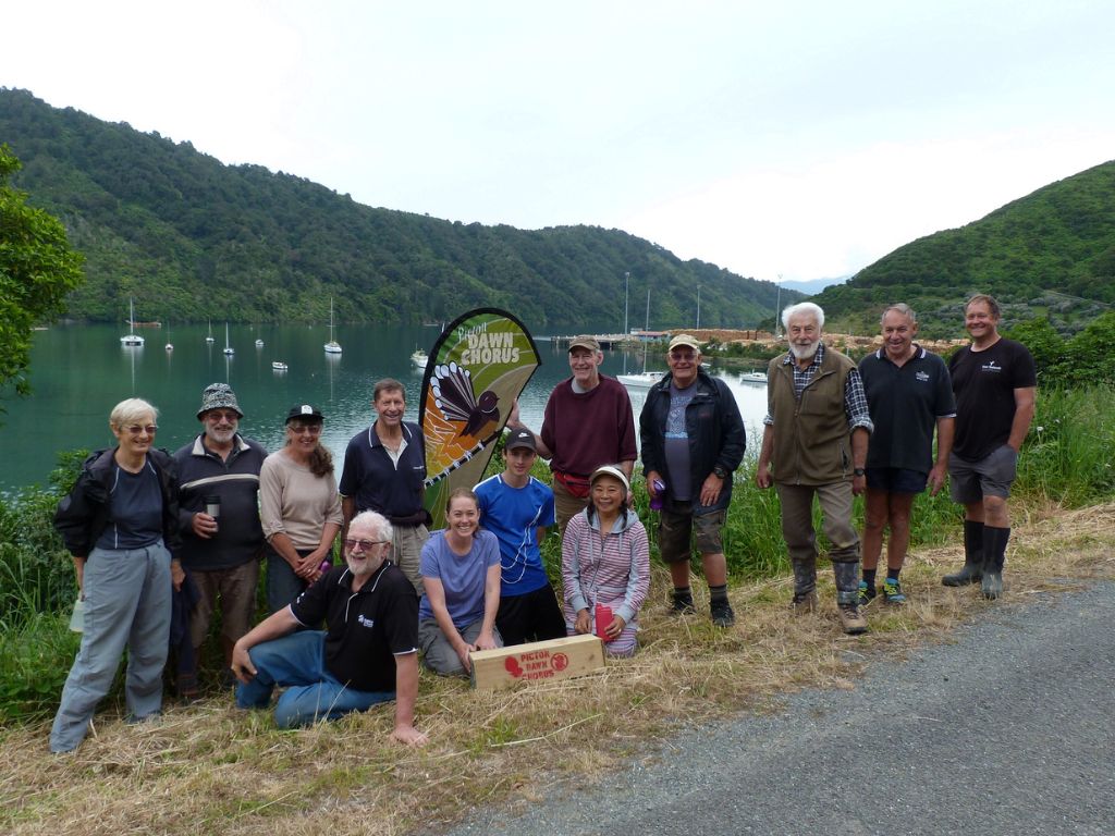 A group of people looking at the camera with a trap box in the foreground.