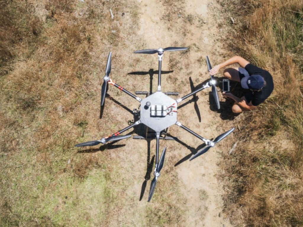 Overhead shot of a person next to a large drone.