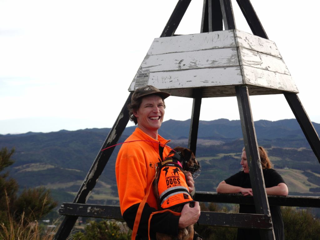 A man wearing hi vis in front of a trig station