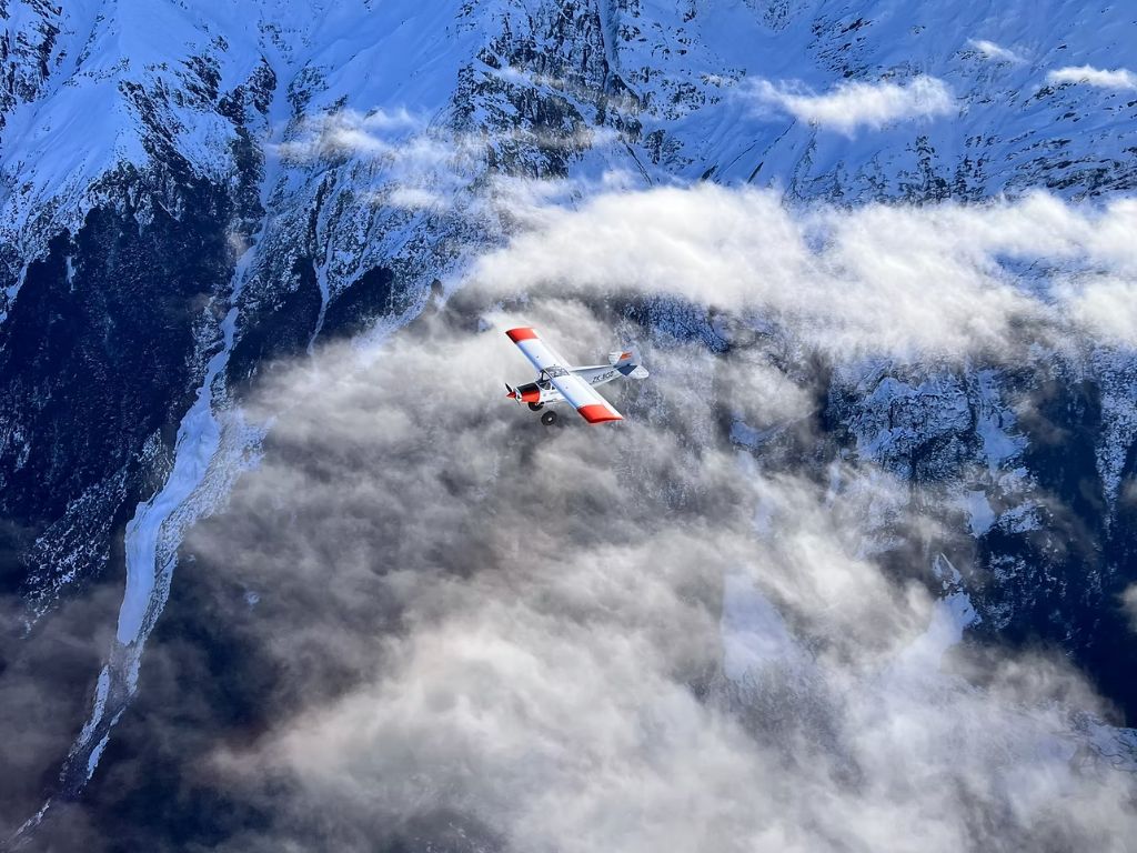 A small plane flying over mountains.