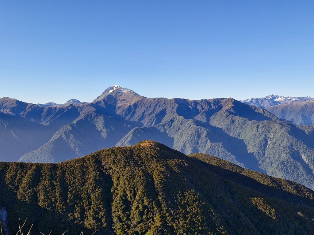 A view of West Coast mountains under blue skies