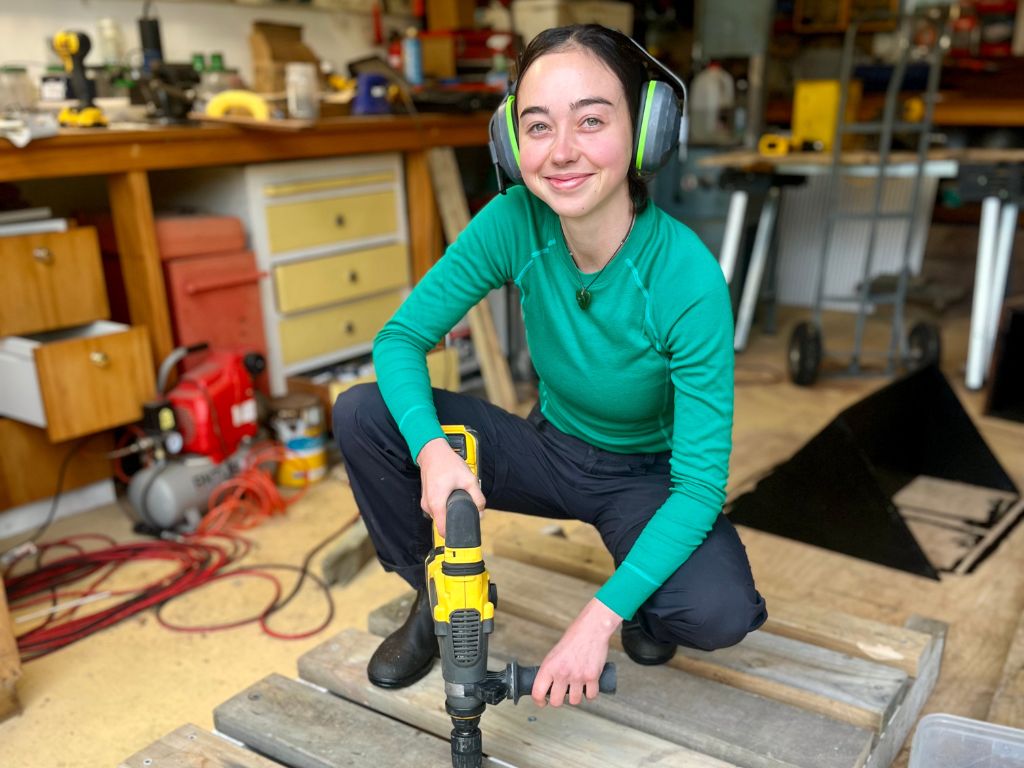 A woman kneeling in a workshop