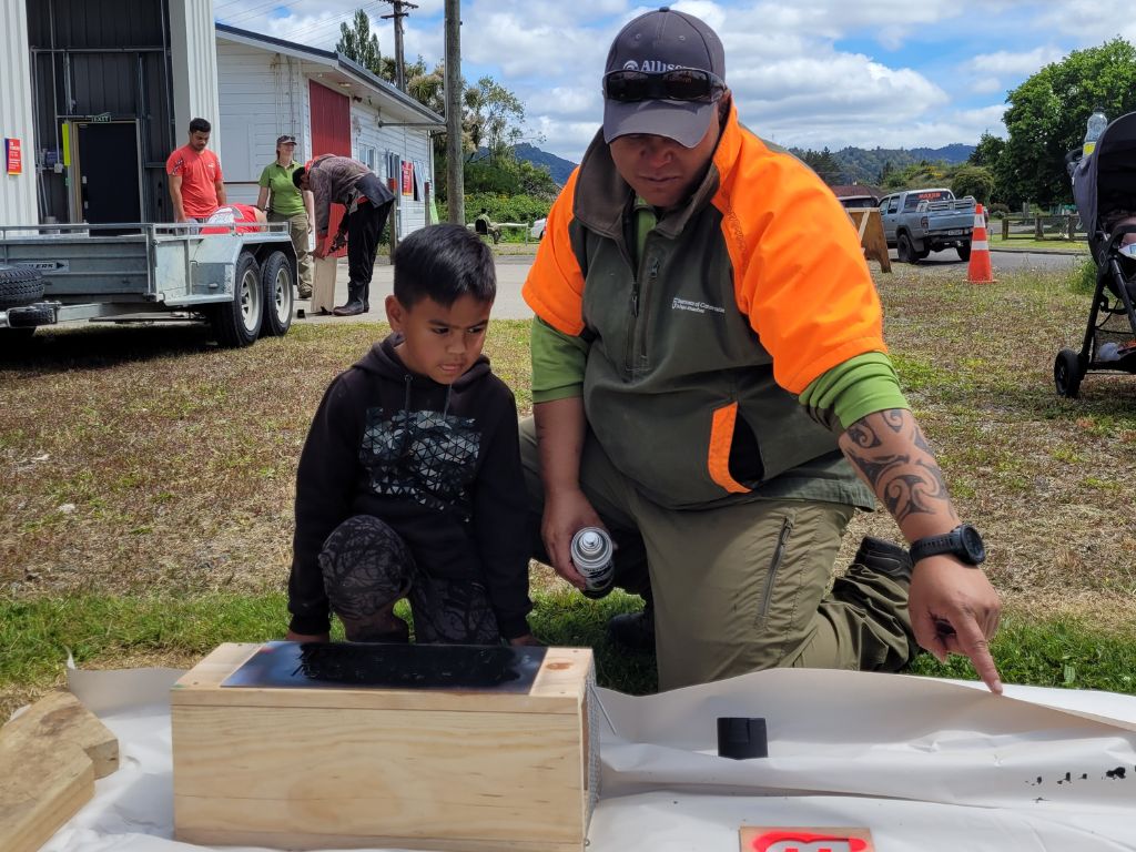 A ranger building a trapbox with a kid.