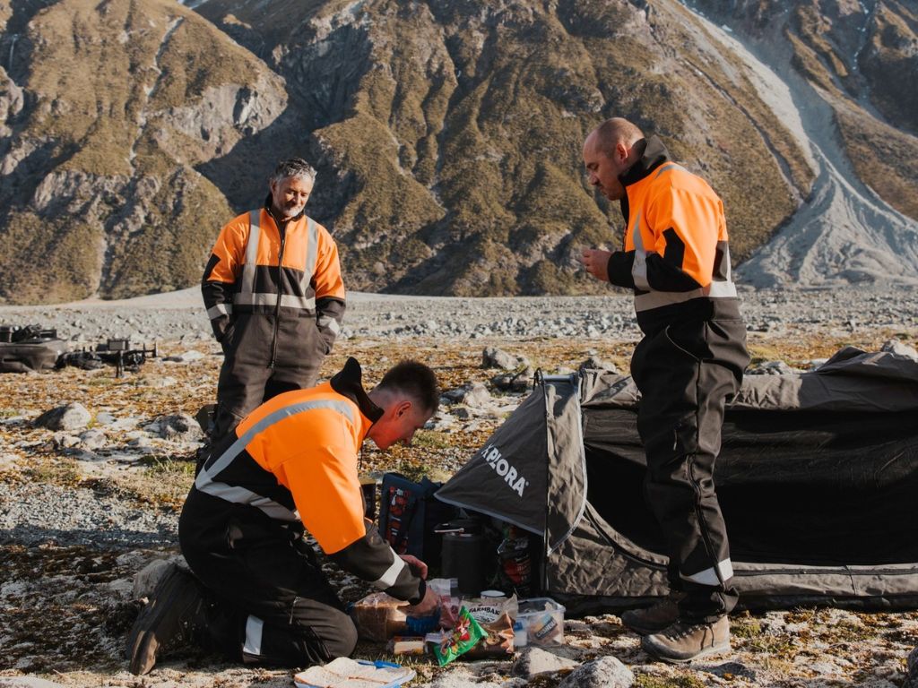 Three people in outdoor clothing in the mountains