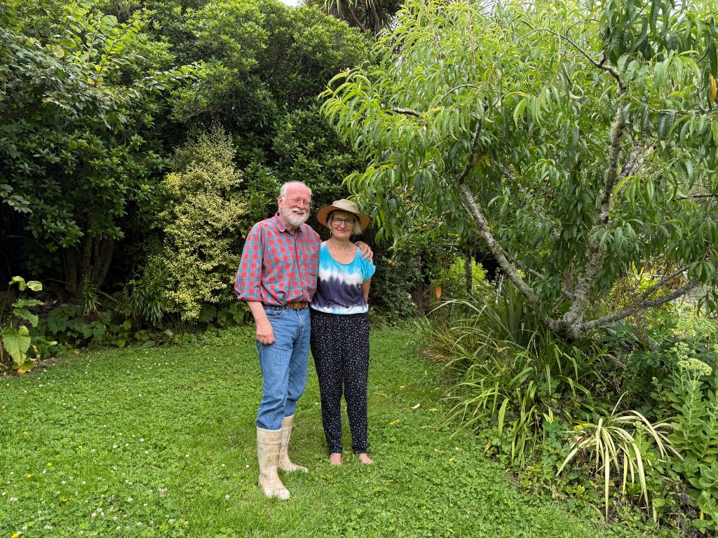 A couple standing on a clearing in the bush.