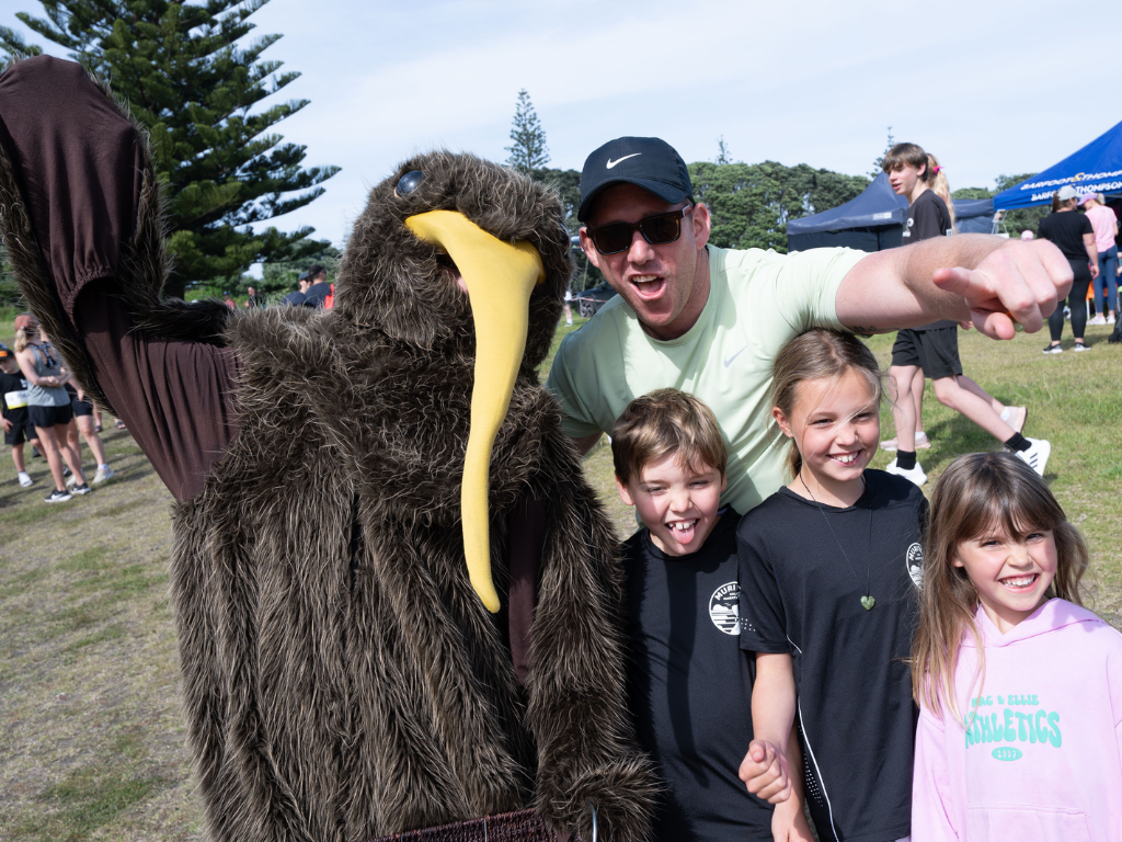 Kiwi mascot with a family group.