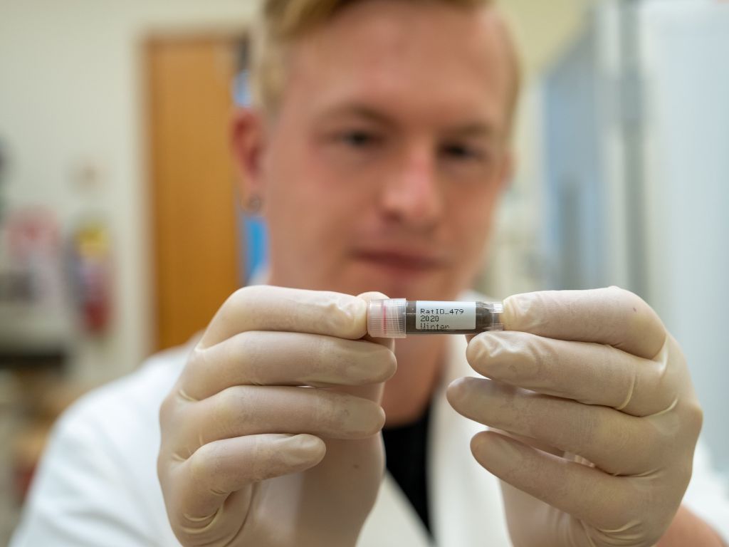 A man holding a sample inside a canister