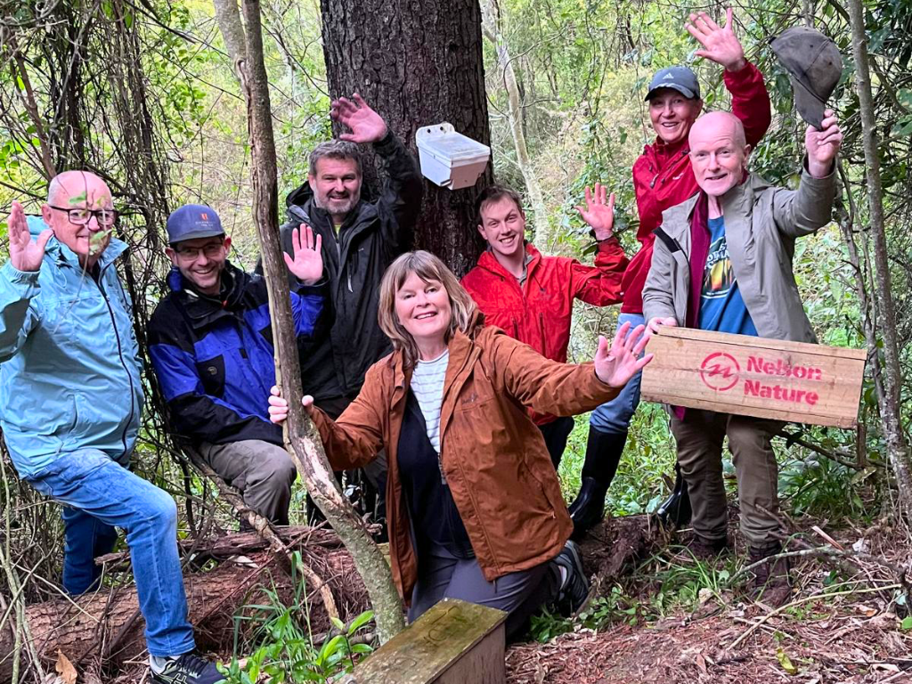 A big group with their hands up in the bush